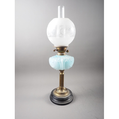 269 - A late 19th century brass oil lamp with milk blue glass reservoir and etched glass shade, on fluted ... 