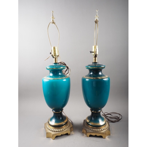 270 - A pair of porcelain teal glazed baluster table lamps with gilt highlights, on a gilt metal square ba... 