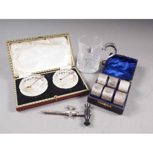 302 - A cased set of six silver plated napkin rings, a glass tankard with plated handle, a cased pair of c... 