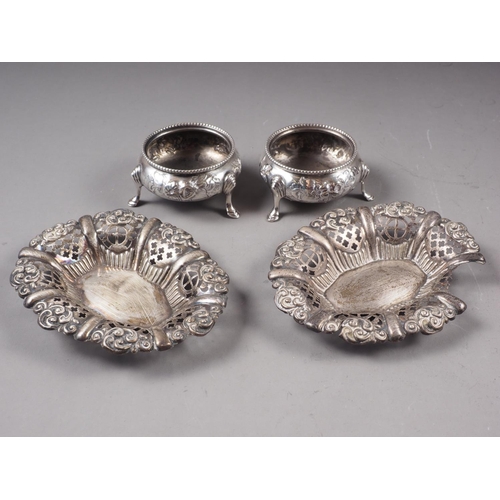 319 - A pair of silver salt cellars with embossed decoration, on three supports, a pair of bonbon dishes w... 