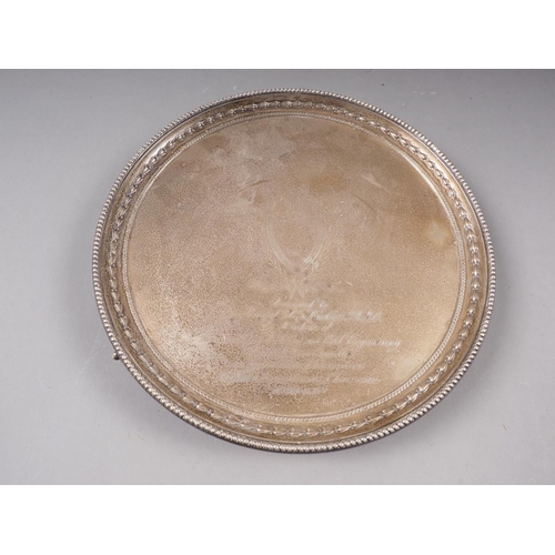 359 - A silver circular card tray with engraved presentation decoration and gadrooned border, on three bal... 