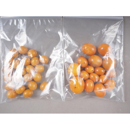 364 - A number of loose butterscotch/egg yolk amber beads, the largest oval bead 16mm wide, and a number o... 