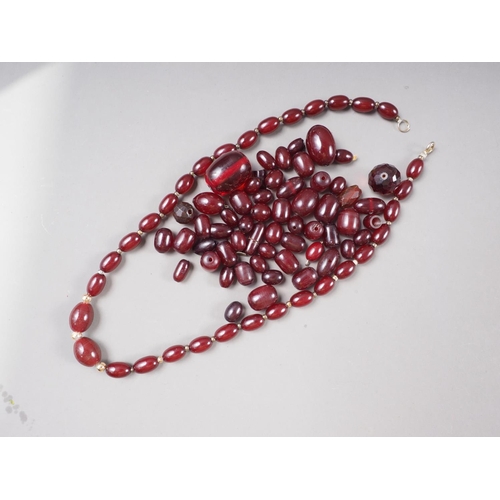 376 - A cherry amber Bakelite graduated bead necklace, the largest oval bead 5mm wide, and a number of loo... 