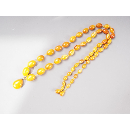 378 - An Art Deco butterscotch/egg yolk graduated bead necklace with silver gilt mounted tear drop-shaped ... 