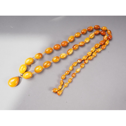 378 - An Art Deco butterscotch/egg yolk graduated bead necklace with silver gilt mounted tear drop-shaped ... 