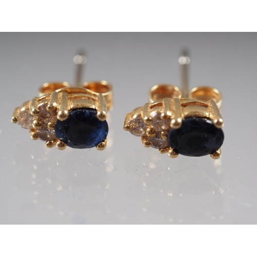 386 - A pair of yellow metal sapphire and diamond ear studs, and a matching cross