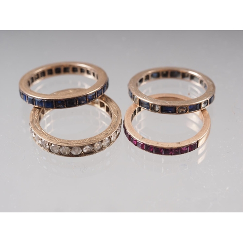 396 - A yellow metal and blue stone eternity ring, a similar yellow metal and clear stone set eternity rin... 