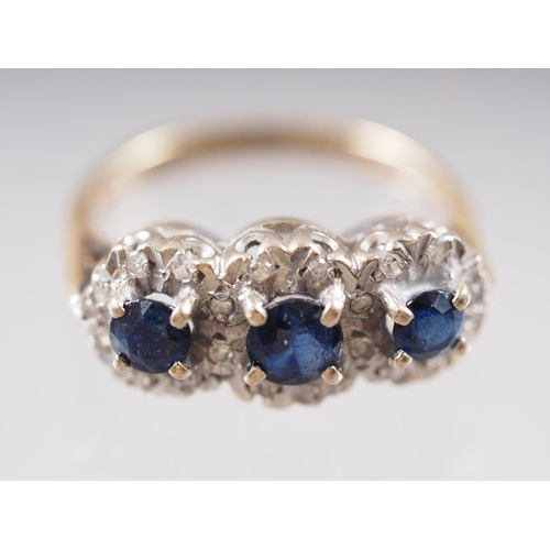 413 - An 18ct gold three-stone sapphire and diamond ring, size G, 3.7g