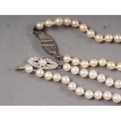 422 - A graduated cultured pearl necklace with 14ct white gold, pearl and diamond clasp, and another simil... 