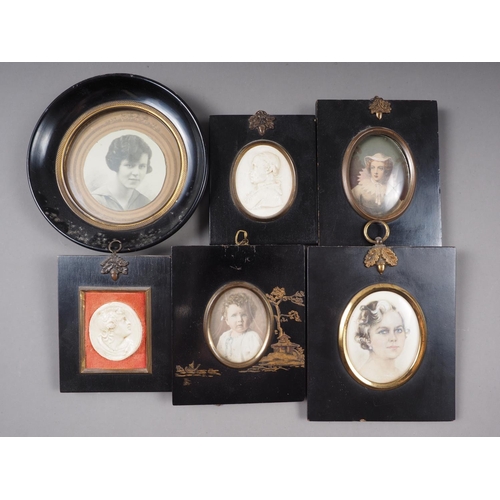 462 - A pair of composition plaques, classical scenes, in circular ebonised frames, a coloured photograph ... 