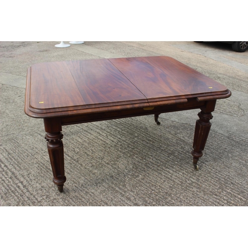 562 - A Victorian walnut extending dining table with two extra leaves, on turned and carved castored suppo... 