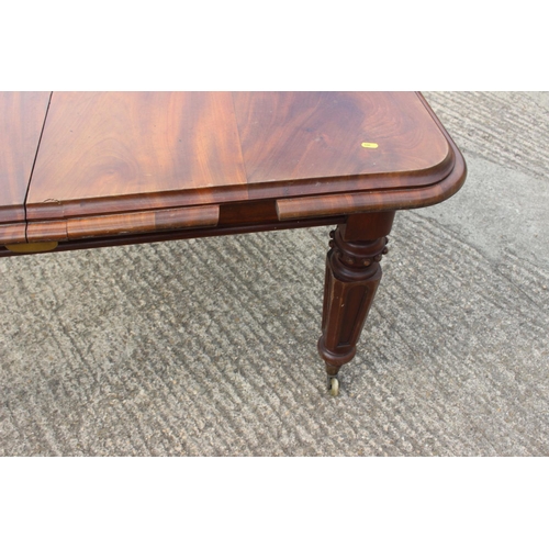 562 - A Victorian walnut extending dining table with two extra leaves, on turned and carved castored suppo... 