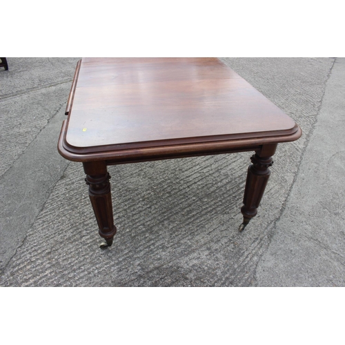 562 - A Victorian walnut extending dining table with two extra leaves, on turned and carved castored suppo... 