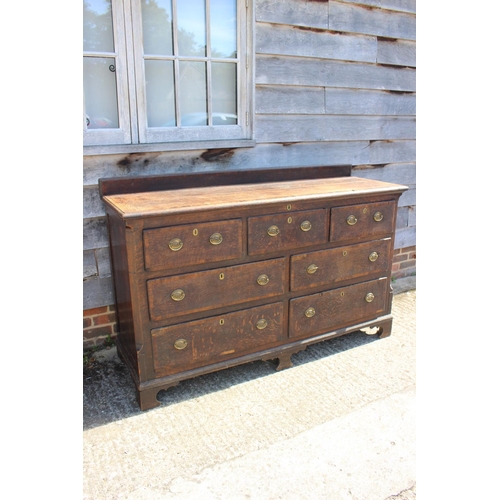 563 - A late 18th century oak and mahogany ledge back sideboard with lift-up top, fitted three short drawe... 