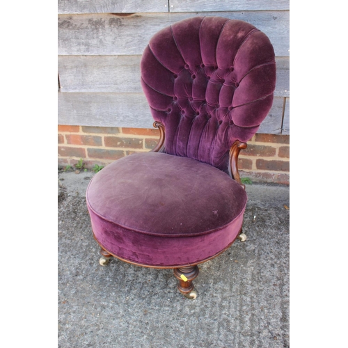 581 - A 19th century mahogany low seat chair with button upholstered back, on turned and castored supports