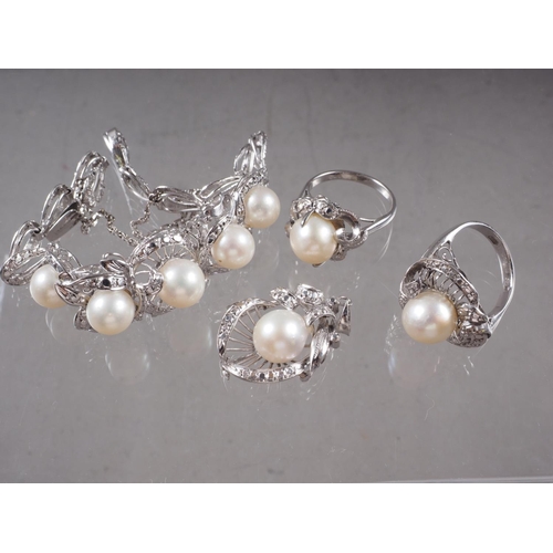 389 - A white metal and pearl set bracelet, two matching dress rings and a pendant