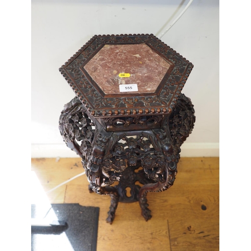 555 - A Chinese carved hardwood hexagonal topped plant stand, inset hardstone, on six carved cabriole supp... 