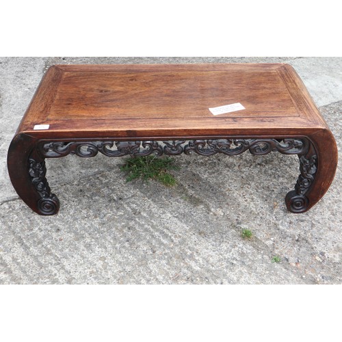 575 - A Chinese carved hardwood low table, on scroll end supports, 37