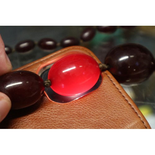 368 - An Art Deco cherry amber Bakelite graduated bead necklace, the largest oval bead 22mm wide, total we... 