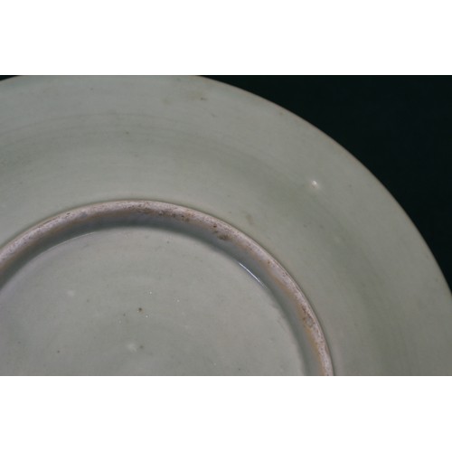 86 - A Chinese celadon glazed plate with incised floral and scrolled decoration, 11 1/2