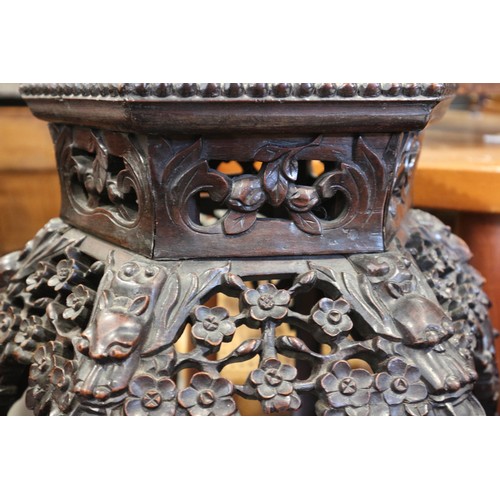 555 - A Chinese carved hardwood hexagonal topped plant stand, inset hardstone, on six carved cabriole supp... 