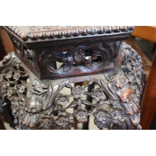 555 - A Chinese carved hardwood hexagonal topped plant stand, inset hardstone, on six carved cabriole supp... 