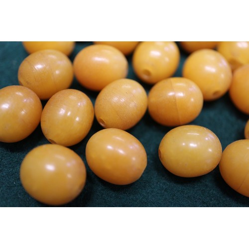 364 - A number of loose butterscotch/egg yolk amber beads, the largest oval bead 16mm wide, and a number o... 