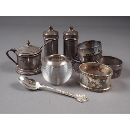 141 - Four silver napkin rings, a silver three-piece cruet set, a silver teaspoon and a glass and silver m... 