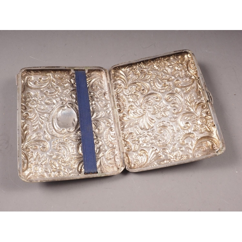 144 - A silver cigarette case with embossed scrolled and floral decoration, 4 1/2