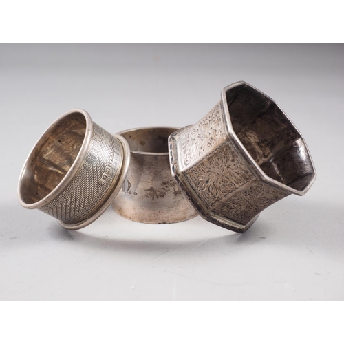 147 - A silver octagonal napkin ring with engraved floral decoration, a silver heavy gauge napkin ring and... 