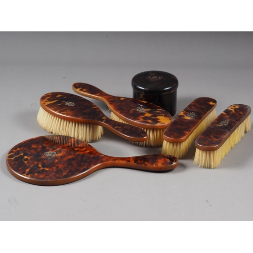 156 - A five piece tortoise shell dressing table set, with yellow metal inlay and a similar dressing table... 