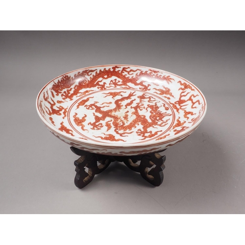 49 - A Chinese iron red porcelain shallow dish, decorated dragons and clouds, six-character mark to base,... 