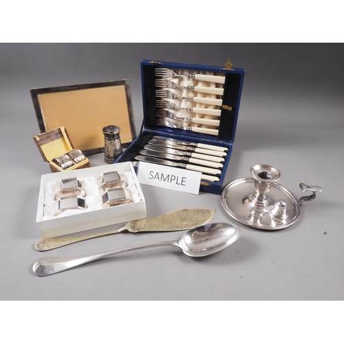 135 - A silver plated chamber stick, a plated pepper grinder, a plated photo frame, loose plated cutlery, ... 