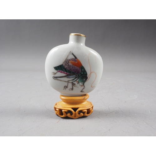 40 - A Chinese porcelain snuff bottle, decorated crickets, seal mark to base, on wooden stand, 2 1/4