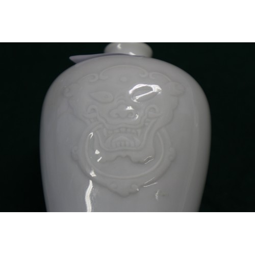 38 - A blanc-de-chine meiping vase with lion mask decoration, on hardwood stand, 7 3/4