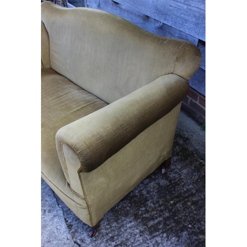 522 - A late 19th century drop-end settee, upholstered in green velour, on square tapered castored support... 