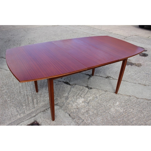 572 - A 1960s sapele mahogany oval extending dining table, by Vanson, with one extra leaf, on moulded spla... 