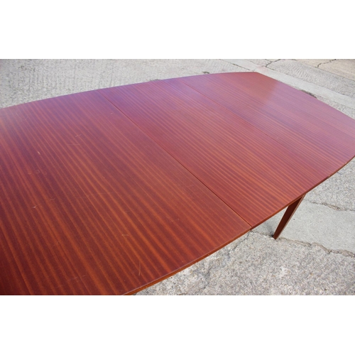 572 - A 1960s sapele mahogany oval extending dining table, by Vanson, with one extra leaf, on moulded spla... 