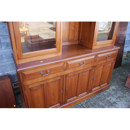 597 - A cherrywood side cabinet, fitted two glazed compartments, central recess over three drawers and thr... 