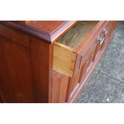 597 - A cherrywood side cabinet, fitted two glazed compartments, central recess over three drawers and thr... 