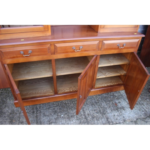 597 - A cherrywood side cabinet, fitted two glazed compartments, central recess over three drawers and thr... 