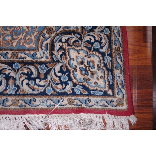 677 - A Persian city rug with scroll design on a red ground and multi-borders, in shades of black, cream a... 