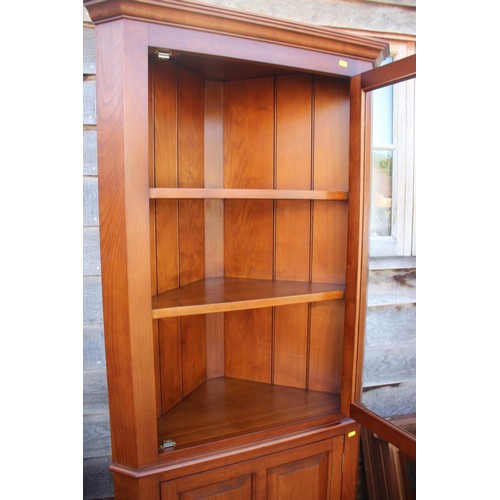 597 - A cherrywood side cabinet, fitted two glazed compartments, central recess over three drawers and thr... 