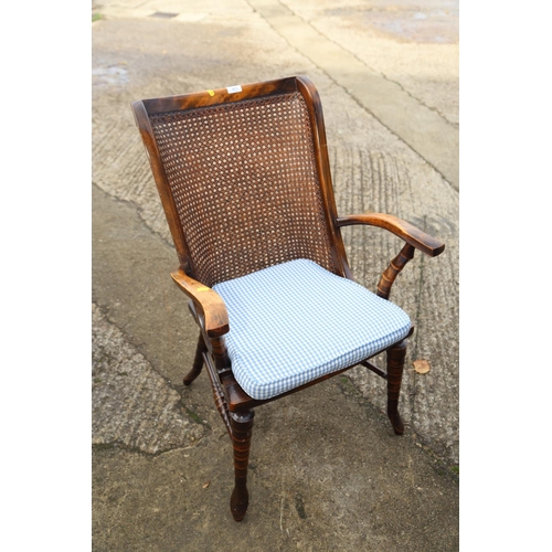 590 - A polished as walnut elbow chair with cane seat and back panels, on turned and stretchered supports