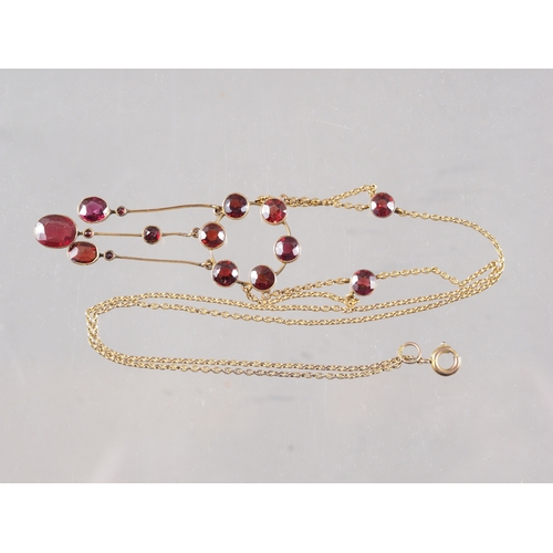 390 - A yellow metal and garnet pendant necklace