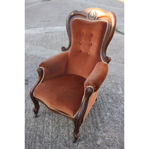 492 - A Victorian carved walnut showframe armchair, upholstered in a rust velour, on cabriole supports