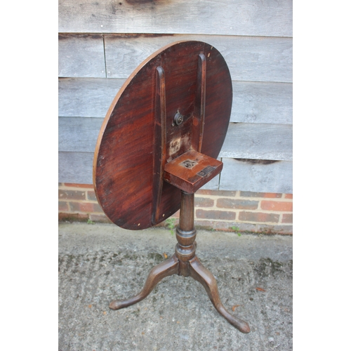 494 - An early 19th century mahogany circular tilt top occasional table, on turned column and tripod splay... 