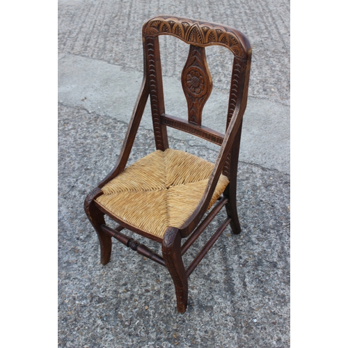 499 - A child's provincial carved hardwood side chair with rush envelope seat, on cabriole stretchered sup... 