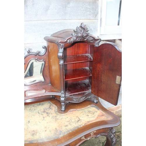 528 - A late 19th century French carved walnut serpentine desk, fitted raised back, mirror panel and cupbo... 