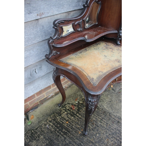 528 - A late 19th century French carved walnut serpentine desk, fitted raised back, mirror panel and cupbo... 